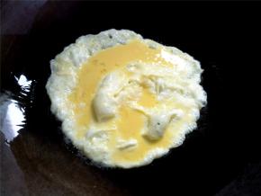 锅烧热，倒入锅底浅浅一层油，转动一下锅，倒入蛋液。蛋液刚刚凝固，就用锅铲铲碎，然后盛起。