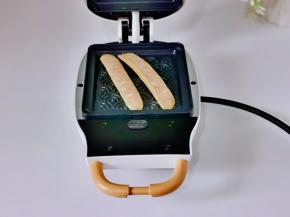 脆皮肠从中间切开，放入烤盘中，盖上盖子3分钟，2根肠同样烤好。