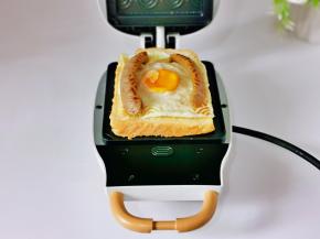 加入煎好的鸡蛋，脆皮肠放两边，如图。