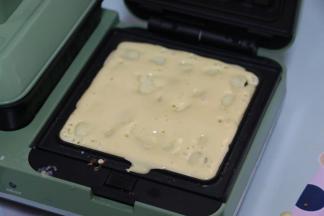 舀一大勺面糊放入摩飞轻食机中。