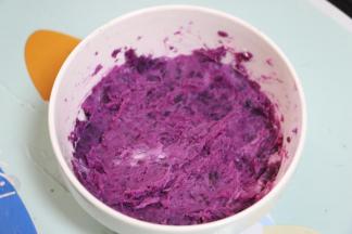 蒸好的紫薯趁热压成泥，加入一勺炼乳，搅拌均匀。