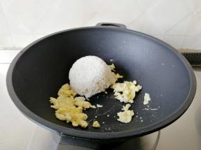放入那一碗米饭。用锅铲将米饭略微按压散开，快速和鸡蛋翻炒均匀。