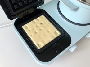 然后把面糊舀入华夫饼盘，如果担心不好操作，可以把面糊装进裱花袋，底部剪一个口，把面糊挤到华夫饼盘里。