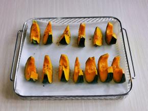 首先将贝贝南瓜洗干净，瓜瓤挖出，再切小块，放入垫好油纸的烤网上，罗勒碎加少许食用油搅拌均匀，刷在每块南瓜上，上下180度烤20分钟。