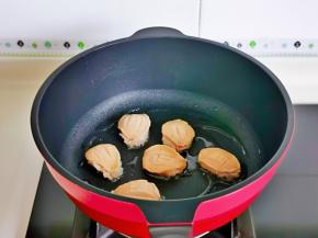 起油锅，加入腌制好的鲍鱼，小火煎。