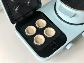 东菱三明治机装好果挞盘，预热2分钟，然后把手抓饼胚放进去。