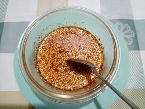 先倒少量油到容器中，然后快速搅拌均匀。不能直接用滚烫的油，会烫焦辣椒粉的，那样会发苦。