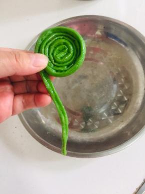 取一根豇豆从里向外，像蜗牛一样卷起来！