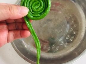 取一根豇豆从里向外，像蜗牛一样卷起来！