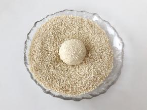 搓圆并在芝麻里来回滚动几次，均匀粘上芝麻。