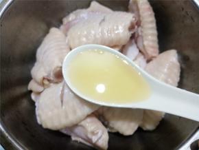 取一个碗，放入鸡翅，加1汤匙料酒，