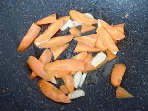 锅底留余油烧热，下入蒜片炒香，下入胡萝卜翻炒至变色。