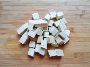 老豆腐冲洗一下切成小块。