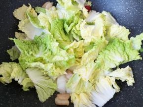 下入白菜叶翻炒至菜叶变软。