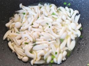 下入白玉菇翻炒至出水。