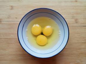 鸡蛋磕入碗中。