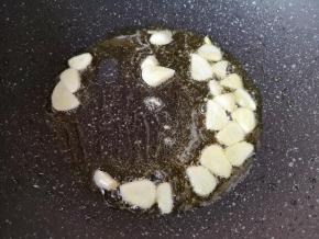 炒锅内继续倒入食用油烧热，下入蒜片炒香。