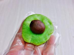 取一块小面团，用掌心压扁，再放上豆沙馅。