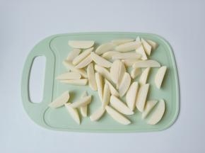 一个土豆先对半切开，半个土豆再平放着切成三到四份，土豆块的大小与厚薄要切成基本上一致的。