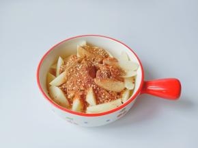 把切好的土豆块放到大的容器里面，放上调味料与芝麻油。