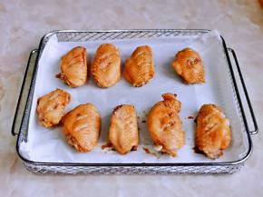 炸网上垫油脂，摆放上腌制好的鸡翅。