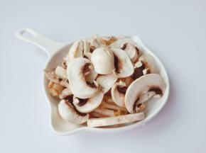 取一个大一点的盆子，盆子里面倒入适量的清水，在水里放点食盐搅拌使其融化，把蘑菇菌柄底部带有沙土的硬蒂去掉，由于这个部位不易洗净，并且人体也不易消化。 然后再将蘑菇放入盐水中清洗两到三遍，清洗好的蘑菇切成片状。