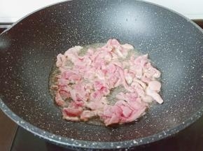 起锅烧油，等到锅里面的水分蒸发干了倒入适量的食用油，凉油下蒜泥爆香，油温升高时放入猪肉丝翻炒。