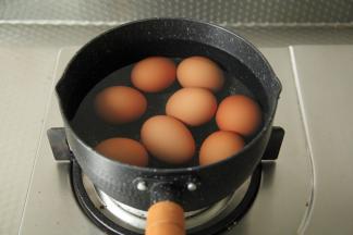将洗干净的鸡蛋先放入不粘小锅中，倒入清水没过鸡蛋，中火煮开至沸腾，将鸡蛋内部煮凝固。