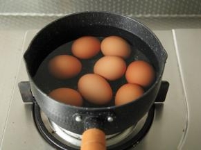 将洗干净的鸡蛋先放入不粘小锅中，倒入清水没过鸡蛋，中火煮开至沸腾，将鸡蛋内部煮凝固。