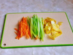 准备备菜，黄瓜去皮切丝，胡萝卜去皮切丝，鸡蛋煎熟后切条。