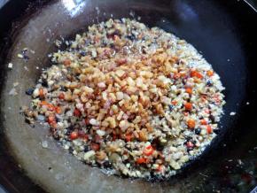 将前面捞起的肉末、瑶柱和海米回锅，翻拌均匀，再炸两三分钟。