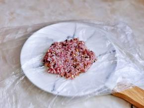 盘子上铺保鲜膜，再放上杂粮糯米饭，借助小勺压平整。