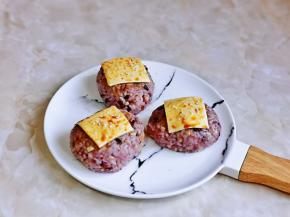 芝士片切小块，每个饭团上放一片，再撒上白芝麻，刷上一层生抽。