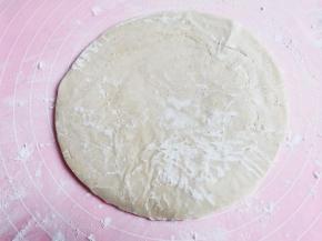 取1张手抓饼，放在撒了一层面粉的揉面垫上，