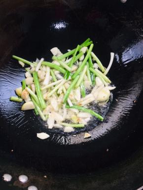 趁着粉浆静置的时候，我们来做个酱汁儿：起锅烧油，放入蒜瓣，葱白爆香！