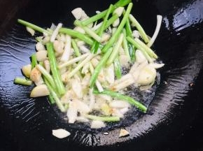 趁着粉浆静置的时候，我们来做个酱汁儿：起锅烧油，放入蒜瓣，葱白爆香！