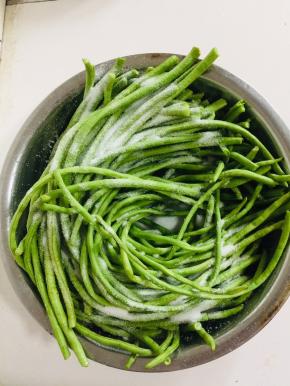 把豇豆放在盆子里，撒上适量的盐！（盐不要放的太多，和平时炒菜差不多的盐就可以了！这样可以促使豇豆快速的发酵变酸，盐如果太多就只有咸味，没有酸味了！）