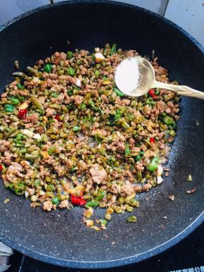 放入少许盐翻炒均匀！（酸豇豆本身就是咸的，只需要再放一点点盐就可以了！）