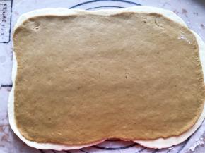 红色面团也擀成薄片，放在白色面团上面