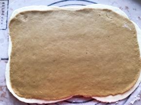 红色面团也擀成薄片，放在白色面团上面