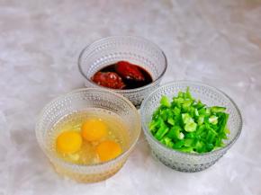 青椒洗干净切丁，辣椒酱，豆瓣酱，生抽混合一起，搅拌均匀，鸡蛋磕碗里用筷子打散。