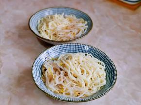 过水的面捞出淋干水分，装入盘中，加入煮熟的豆芽。