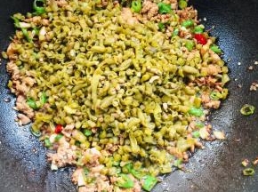 放入酸豇豆翻炒均匀！