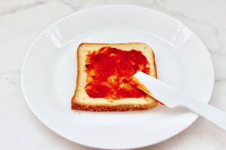 取一片吐司，上面先均匀抹上一勺披萨酱。