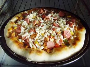 11.将鸡丁馅料均匀的放在饼上，馅料之间适量的撒上奶酪丝