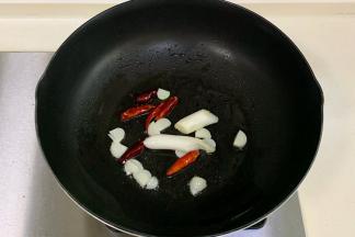 锅中倒入食用油烧热，下入葱、蒜和干辣椒爆香。