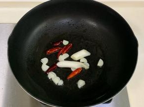 锅中倒入食用油烧热，下入葱、蒜和干辣椒爆香。