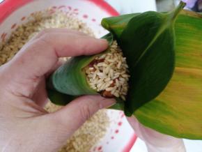 左手食指和大拇指夹住顶部，往中间挤一点点，其余三指托住下面。