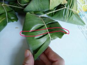 红框处是粽子盖下来的边缘，绳子就是垂直于这个边缘绕一圈，打个死结。