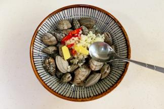 花甲洗净，加入蒜、姜和小米辣，倒入食用油。